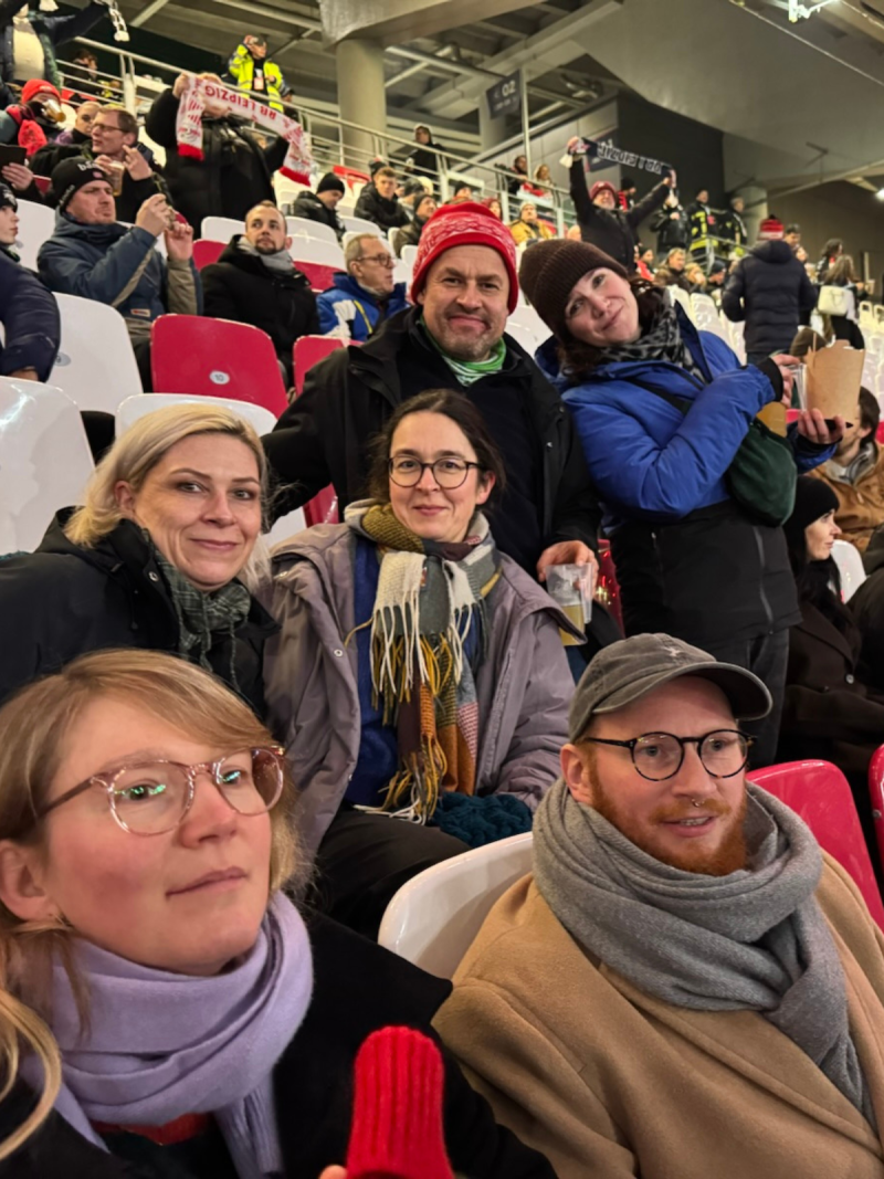 Claudia Maicher, Grüne Stadtratsabgeordnete und weitere Grüne Aktive sitzen auf der Tribüne im Stadion von RB Leipzig