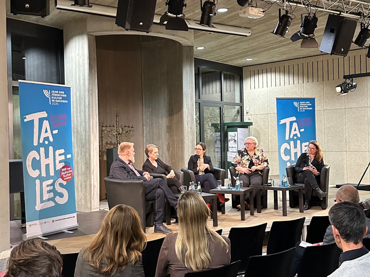 Claudia Maicher zusammen mit drei Frauen und einem Mann auf dem Podium im Ariowitschhaus. Im Hintergrund zwei Aufsteller mit der Aufschrift Tacheles